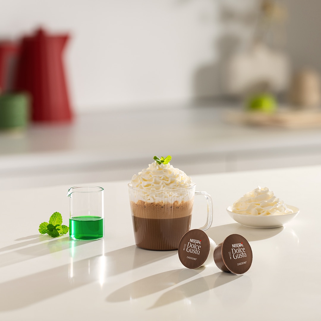 iced cappuccino next to a coffee capsule