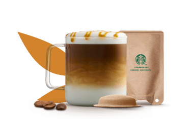 tasse avec un caramel macchiato à côté d'un pod et d'un sachet à base de papier
