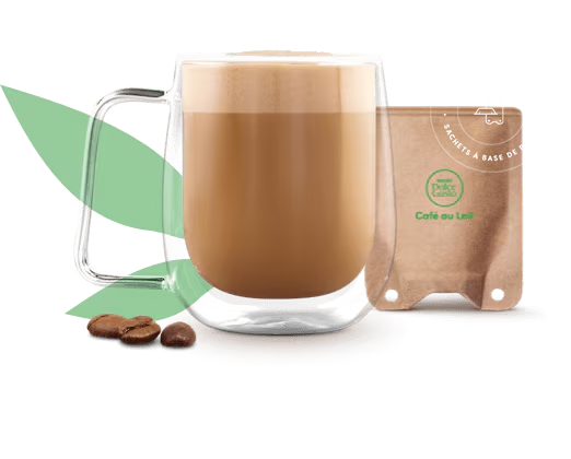 café avec du lait dans une tasse à côté d'un sachet à base de papier