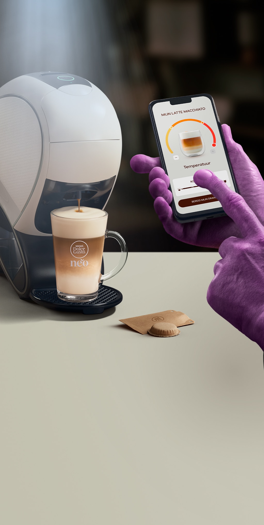 Een alienhand die de NESCAFÉ Dolce Gusto-app gebruikt om een koffie te personaliseren. NEO Latte-koffiemachine, koffiedoos en dranken.